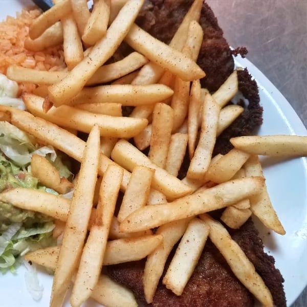 San Diego's Mexican Grill's carne asada with a side of french fries, rice, guacamole, and lettuce.