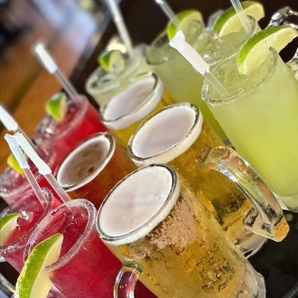 A tray of San Diego's Mexican Grill drinks, including red and green margaritas, and mugs of beer.